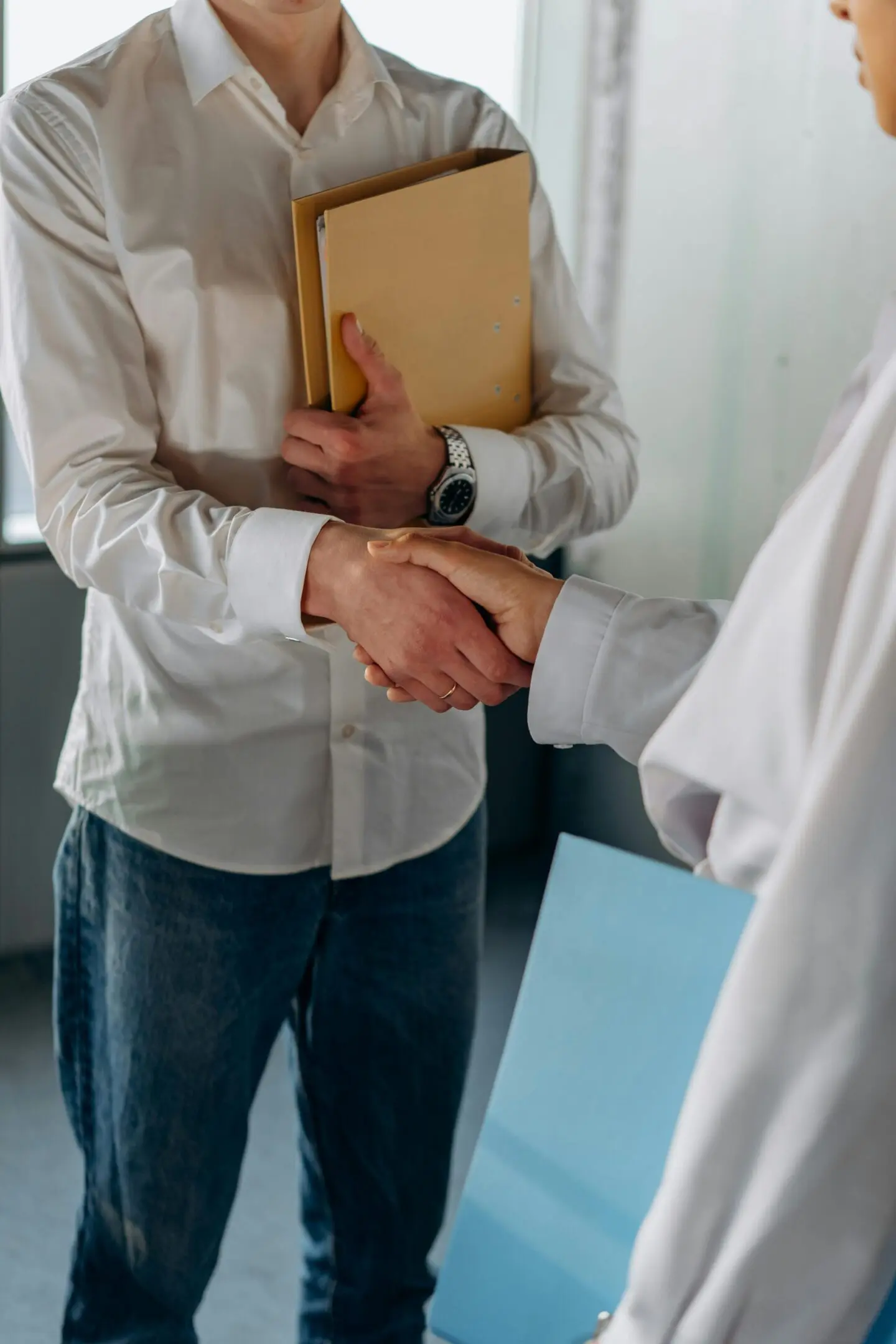 Two people shaking hands in a casual setting.